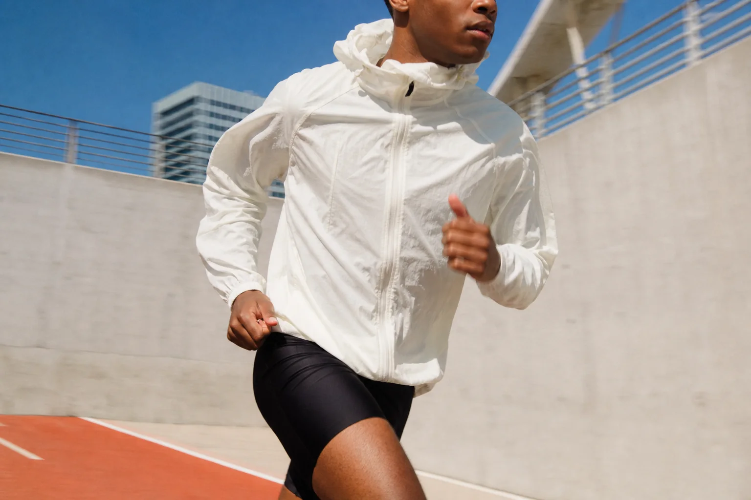 An athlete caught mid-stride against a clear blue sky